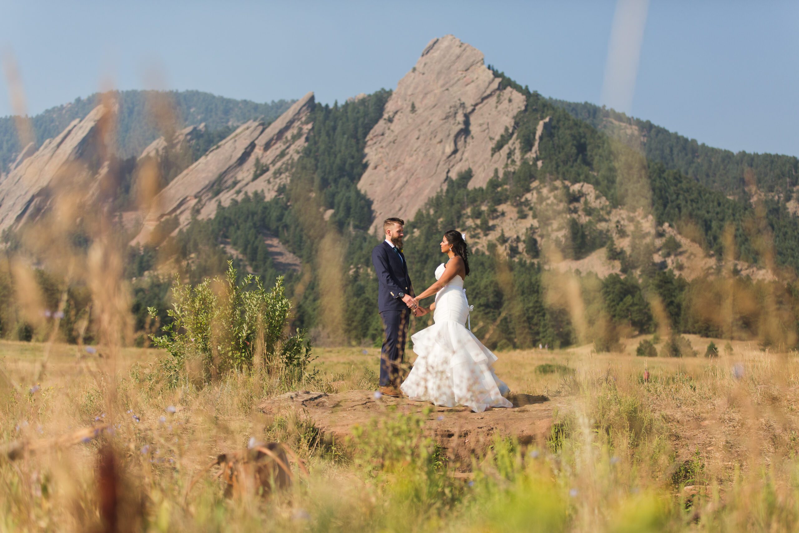 Boulder Chautauqua Dining Hall wedding couple pose for photo in front of Flatirons