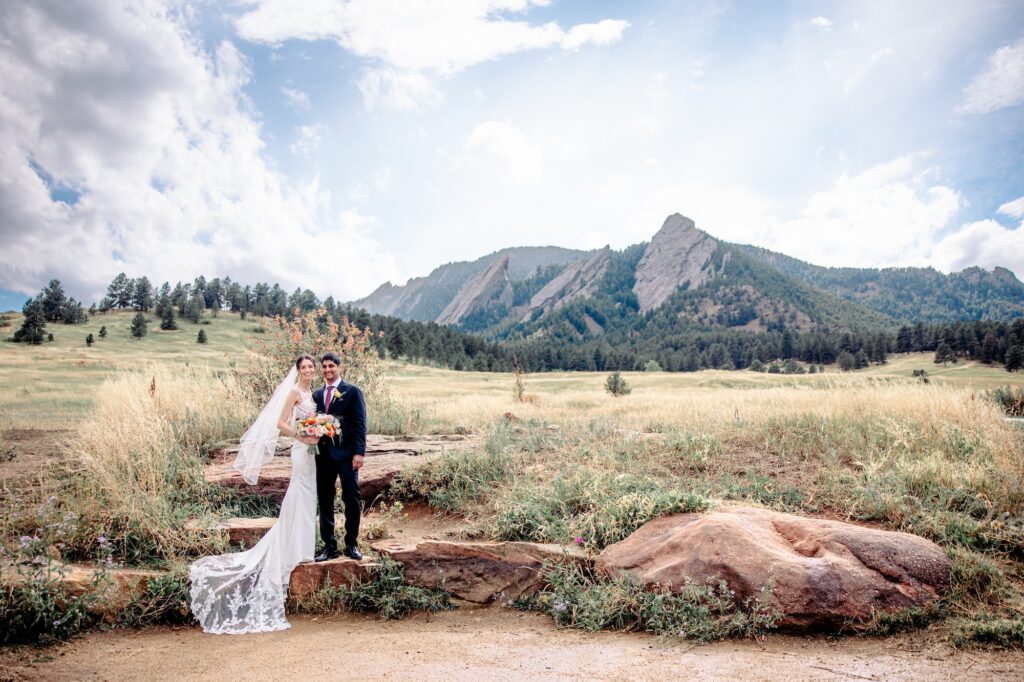 colorado wedding couple post in front of boulder flatirons during the portrait portion of their day-of wedding timeline