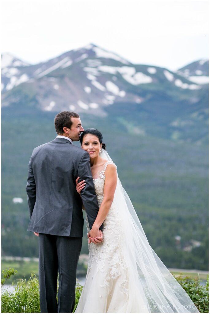 a colorado wedding couple pose in front of rugged mountains in breckenridge