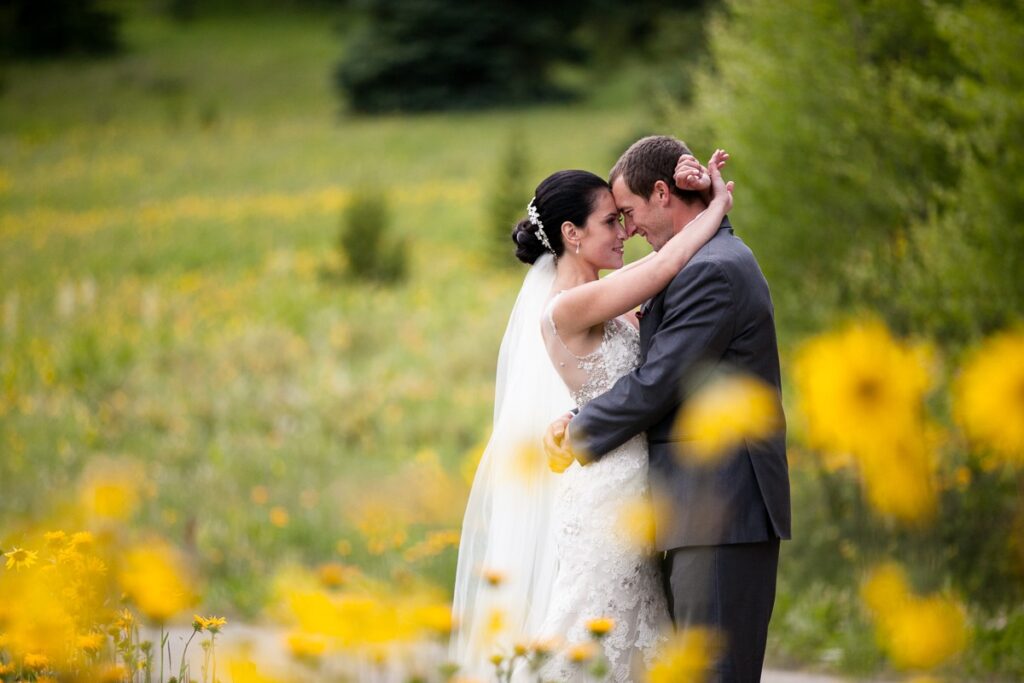Colorado wedding couple hug behind yellow wildflowers in Breckenridge, Colorado