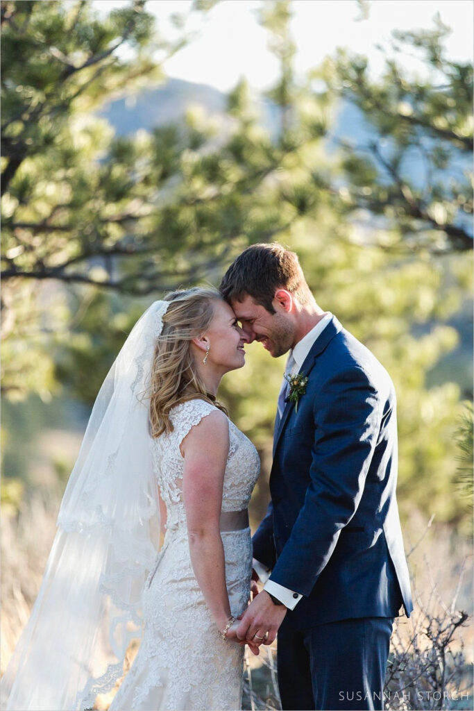 Lionscrest Manor wedding couple bride and groom hold hands and look at each other white celebrating at Lionscrest Manor, a Lyons Colorado wedding venue