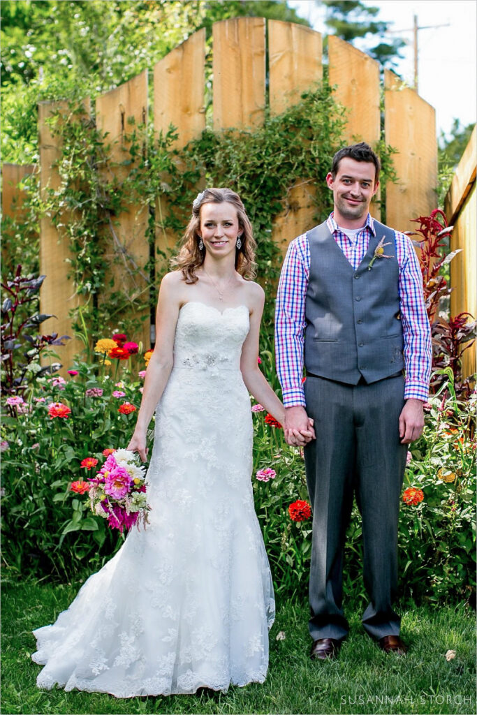 Lyons Farmette wedding couple Wedding couple hold hand in front of a fence in Lyons, Colorado