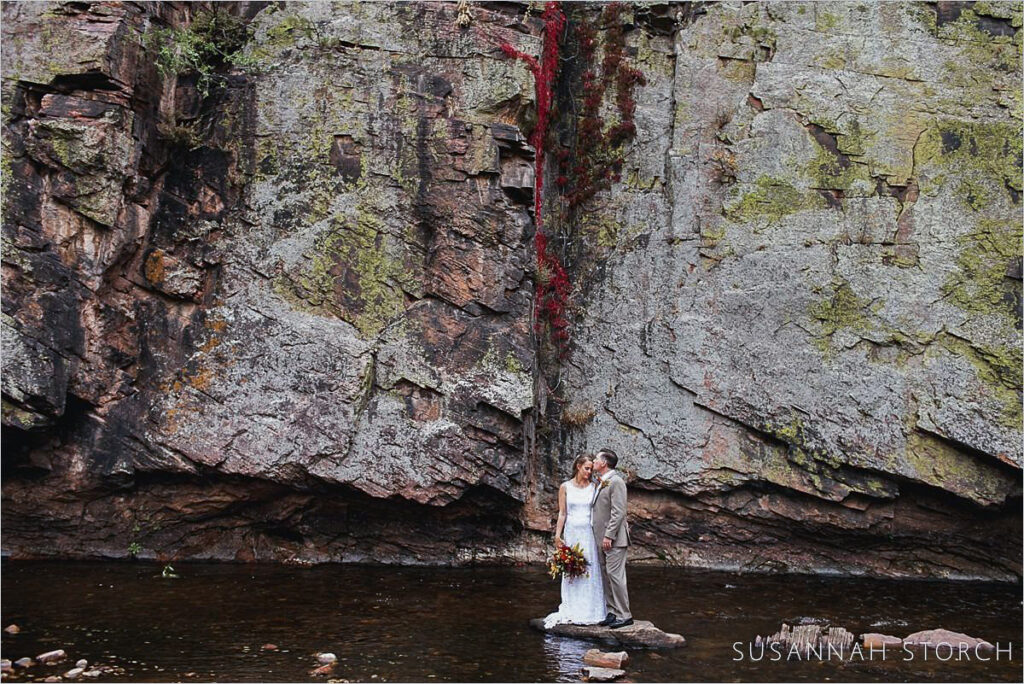 Planet Bluegrass, Lyons, Colorado Wedding couple pose in river at Planet Bluegrass, a Lyons Colorado wedding venue